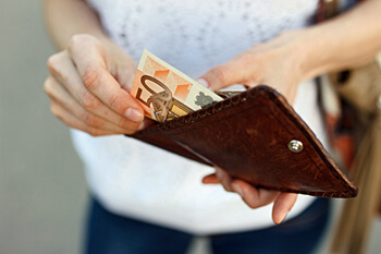 Frau hält Geldbörse mit Geldschein