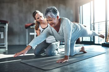 Sporttherapeutin macht sportliche Übungen mit älterer Frau